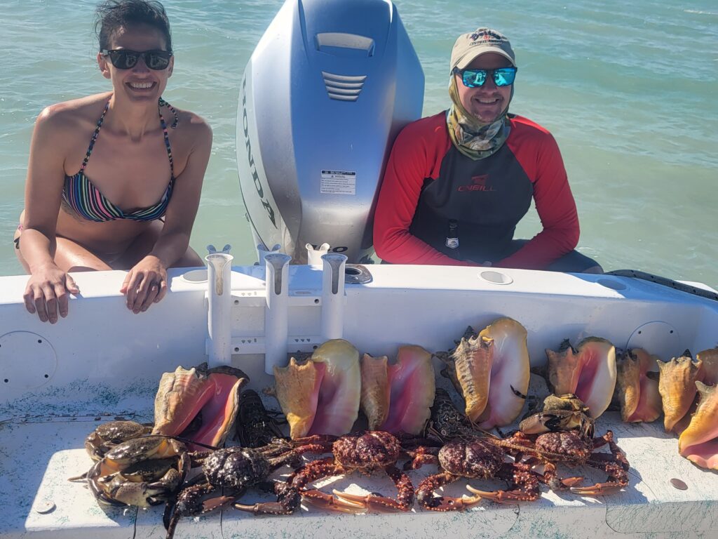  "A successful angler on the boat showing off a large catch of fresh conch and local crabs."