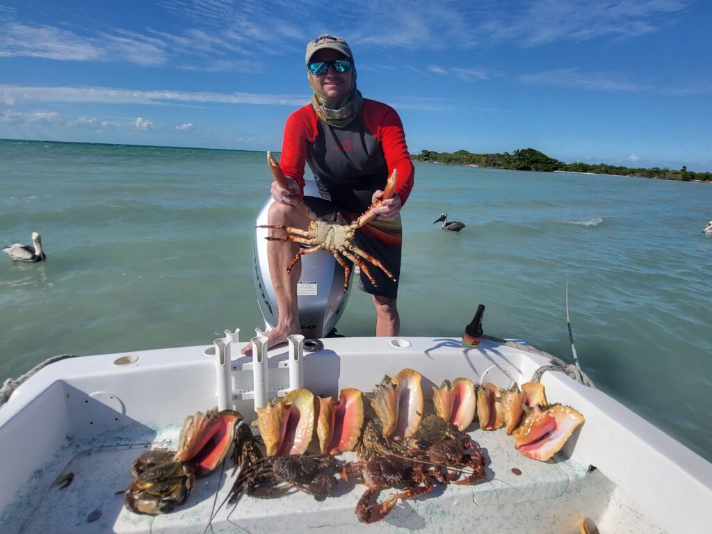 "A happy customer proudly displaying a fresh Caribbean spiny lobster caught during a private reef excursion in San Pedro."