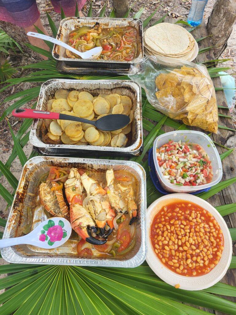 "Authentic Belizean beach BBQ feast featuring grilled lobster, fish, and local sides."