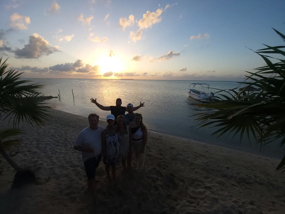 Sunset beach dinner in Belize featuring fresh jerk chicken, ribs and scalloped potatoes with homemade tortillas on a Fish 101 Belize tour after stops at Secret Beach, Sandbar Island,and Bird Island.