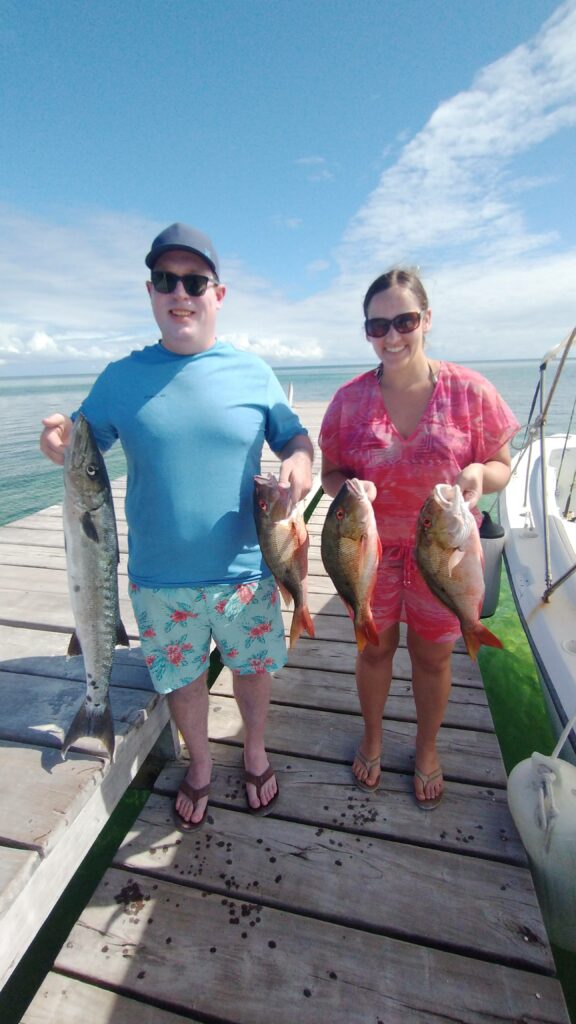 "Fishing guests posing with their day's catch on a sun-drenched dock in San Pedro."