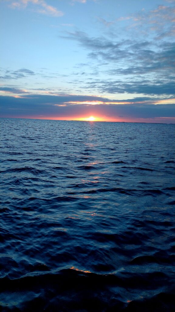 "The deep blue sky and sea at dusk with the last glow of the sunset on the horizon after a day of fishing."
